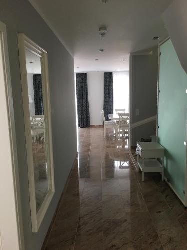 a hallway with a mirror and a table and chairs at Merkel Villa Apartamente in Wiesbaden