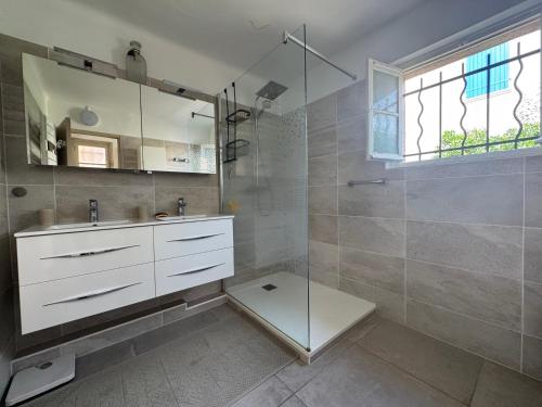 une salle de bain avec un lavabo et une douche en verre dans l'établissement Maison élégante à 100 m de la mer, à Fréjus