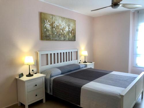 a bedroom with a bed with two night stands and two lamps at Vivalidays - Estrella de Mar - Calella in Calella