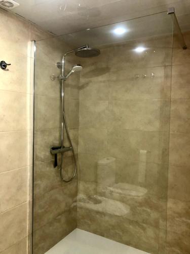a shower with a glass door and a sink at Vivalidays - Estrella de Mar - Calella in Calella