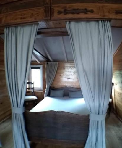 a bedroom with a bed with blue curtains at den overkant in Diksmuide