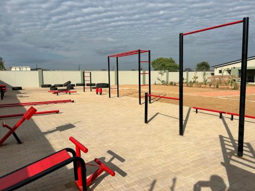 a group of red benches on a tennis court at LLL Apartments in Gaborone