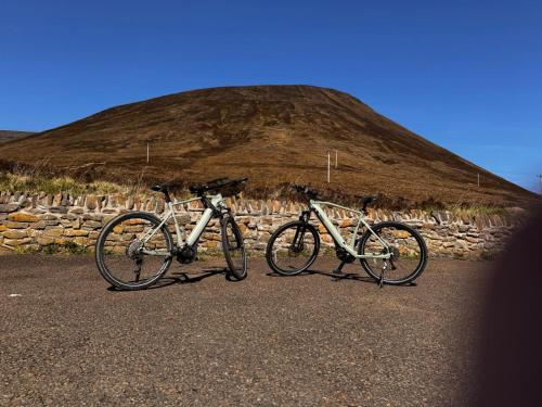 two bikes parked next to each other in front of a hill at Aurora - Self Catering, Kirkwall, Quiet Location with Luxury Hot Tub in Orkney