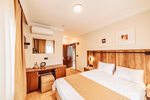 a hotel room with a bed and a desk at The Lume Boutique Hotel & Restaurant & Spa in Bodrum City