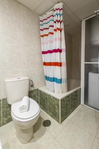 a bathroom with a toilet and a shower curtain at Zafiro Calpe by Concept Flats in Ifach
