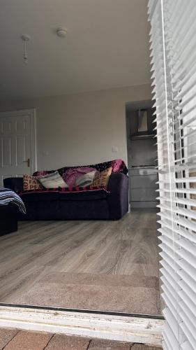 a living room with a couch in the corner of a room at Studio Apartment in Letterkenny