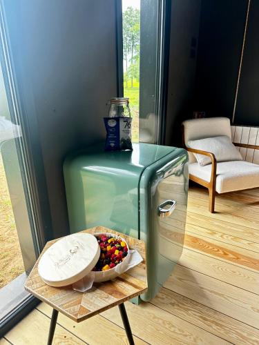 a glass table with a bowl of candy on a table next to a refrigerator at Le Vert d'Orezza-Bain nordique privatif in Valliquerville