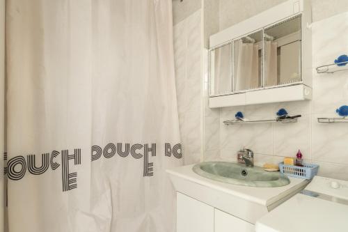 une salle de bain avec un lavabo et un rideau de douche dans l'établissement Appartement 2 personnes A22, à Pornic