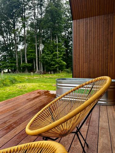 a yellow bench sitting on a wooden deck at Le Vert d'Orezza-Bain nordique privatif in Valliquerville