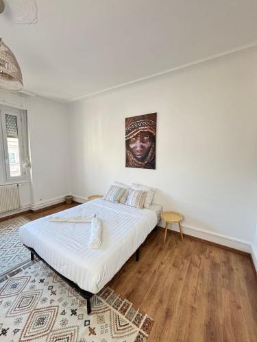 a bedroom with a bed and a painting on the wall at Soh Rent appartement Schiltigheim - 4p - TV - wifi - Balcon in Schiltigheim