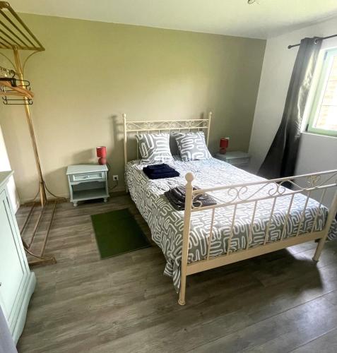 - une chambre dotée d'un lit avec un cadre blanc dans l'établissement Le Poulailler du Perche Gîte, à Marchainville