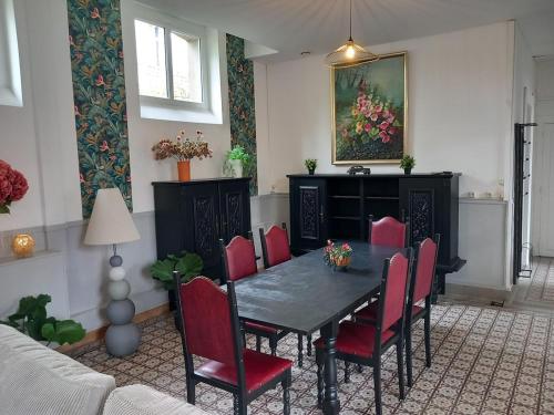 une salle à manger avec une table et des chaises rouges dans l'établissement Tourelles Gîte B - 8 pers, à Caffiers
