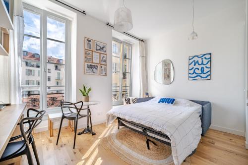 une chambre avec un lit, une table et des chaises dans l'établissement Studio lumineux Centre-ville, à Nice