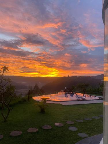 a sunset over a swimming pool at a resort at Pinggan Cliff in Baturaja