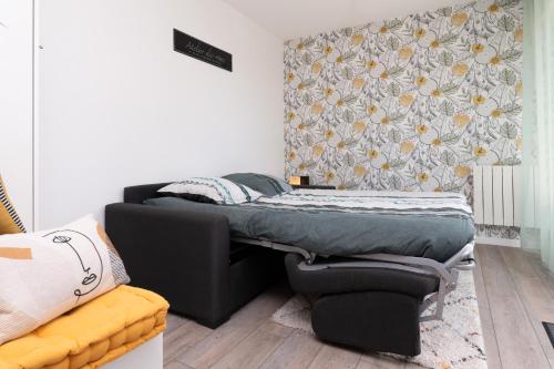une petite chambre avec un lit et un canapé dans l'établissement Studio Proche Port Terrasse et Wifi, à Vannes