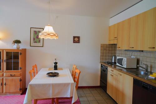 a kitchen with a table with a white table cloth at Chalet Miravalle 2 in Wengen