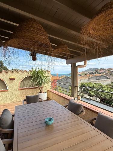 - une table avec des chaises et une vue sur la ville dans l'établissement Casa Zélie Superbe T4 vue mer, Clim ,Wi-Fi, à Collioure
