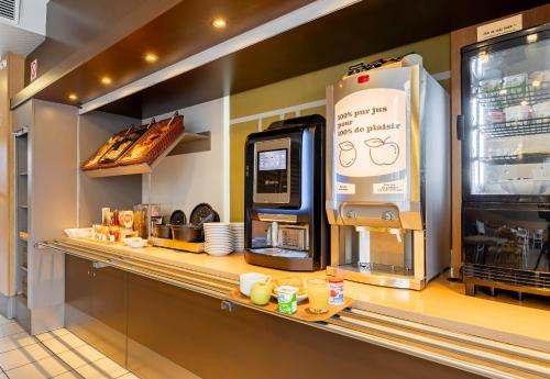 a kitchen with a counter with a coffee machine at B&B HOTEL Valenciennes Marly in Marly
