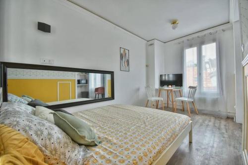 a bedroom with a bed and a table with chairs at Alice aux pays des merveilles in Maintenon