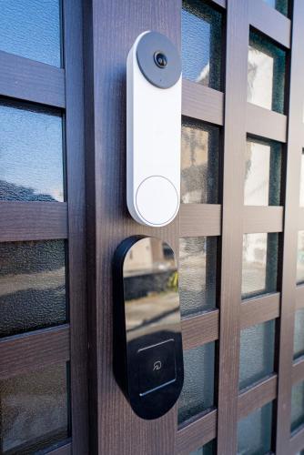 a door opener on a wooden door with a window at Takumi Renovated House Osaka Hirakata with Free Parking in Hirakata