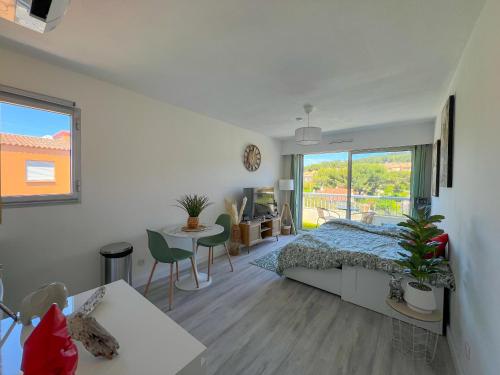 a bedroom with a bed and a desk and a window at Studio Emeraude Proche Plage Clim Balcon Dernier Etage Parking - Saint Mandrier Sur Mer - Pin Rolland in Saint-Mandrier-sur-Mer