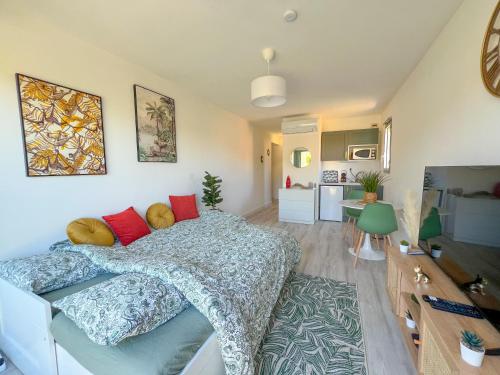 une chambre avec un lit et un salon dans l'établissement Studio Emeraude Proche Plage Clim Balcon Dernier Etage Parking - Saint Mandrier Sur Mer - Pin Rolland, à Saint-Mandrier-sur-Mer
