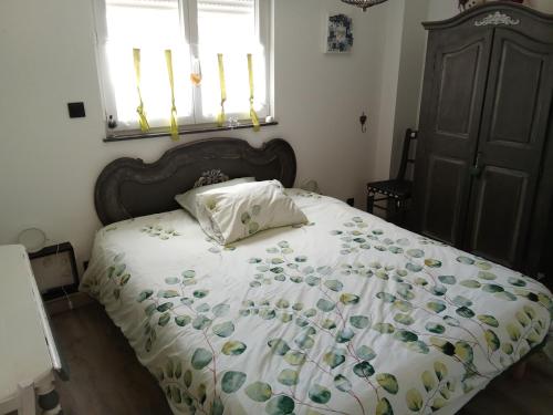 a bedroom with a bed with a white comforter at AU PETIT BONHEUR Chez l'habitant 2PERS in Ferques