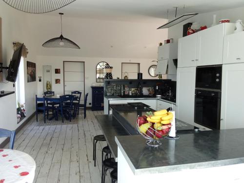 a kitchen with a bowl of fruit on a counter at AU PETIT BONHEUR Chez l'habitant 2PERS in Ferques