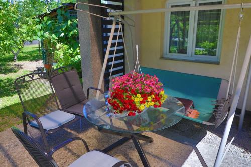 Una mesa de cristal con un ramo de flores en un patio. en Apartman Ozimice 2, en Bihać