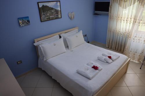 a blue bedroom with a bed with towels on it at Villa Nano in Berat