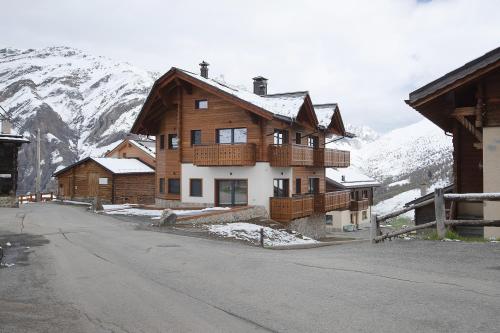 a large wooden house in the mountains with snow at Chalet Kb in Livigno
