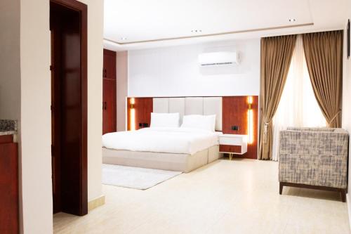 a bedroom with a white bed and a window at Abuja Apartments - The Meridian in Abuja