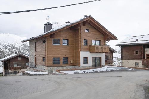 a large wooden house with snow on the ground at Chalet Kb in Livigno