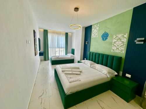 a bedroom with a large bed with a green headboard at EKAM Sun Apartments in Golem