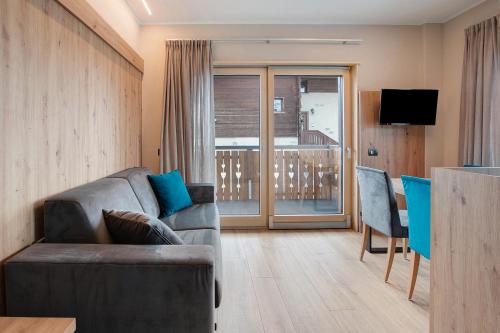 a living room with a couch and a table and a television at Chalet Kb in Livigno