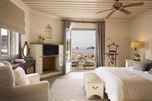 a bedroom with a bed and a couch and a tv at Porto Kea Suites by Sandglass in Korissia