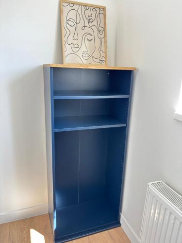 a blue book shelf with a box on top at Soh Rent Appartment 3 Schiltigheim TV Wifi in Schiltigheim