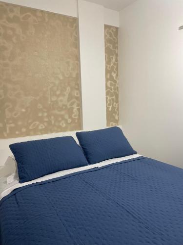 a blue bed with blue pillows in a bedroom at BAHIA FLAT Apt 222 in Salvador