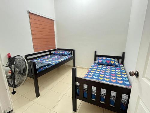 a bedroom with two bunk beds and a fan at Ummu Homestay 03 in Batu Gajah