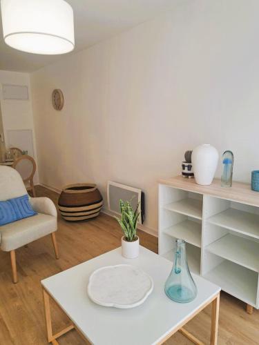 - un salon avec une table blanche et une chaise dans l'établissement Résidence d'Agen, à Agen