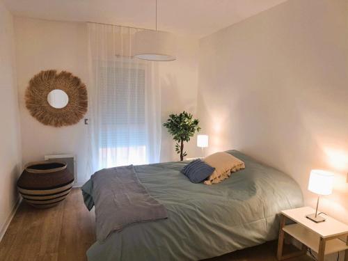 une chambre avec un lit et deux lampes et une fenêtre dans l'établissement Résidence d'Agen, à Agen