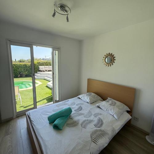 une chambre avec un lit et une grande fenêtre dans l'établissement Villa moderne ***** proche mer et montagne ., à Vence