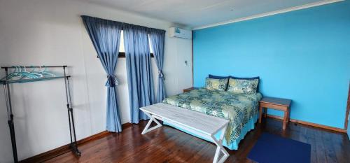 a bedroom with a bed and a window with blue curtains at Xai Xai Mozambique, Fish Eagle, Xai Xai Beach Front in Xai-Xai