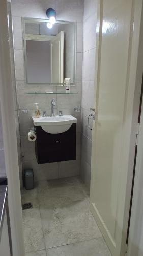 a white bathroom with a sink and a mirror at Moreno924 in Barraquero