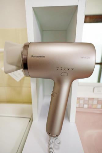 a hair dryer in a shelf in a salon at Takumi Renovated House Osaka Hirakata with Free Parking in Hirakata