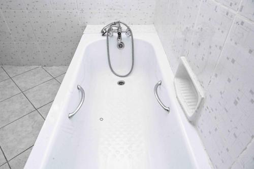 a white bath tub with a shower in a bathroom at Sofitel Executive 4 bedrooms all ensuite own compound in Kisumu