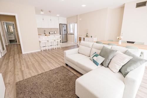 a living room with a white couch and a kitchen at Casa Foros de Amora in Amora