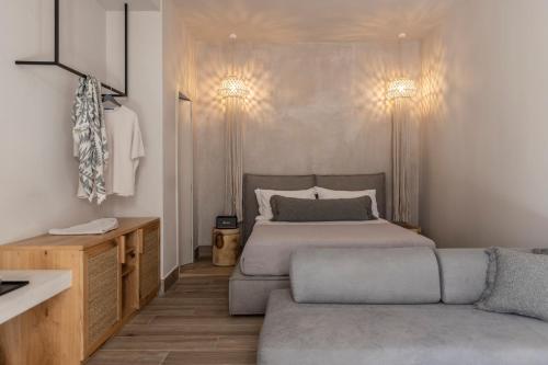 a bedroom with a bed and a couch at Nikoleta Hotel and Villas in Limenas
