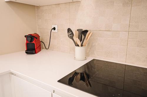 a kitchen counter with a cup of utensils on it at Casa Foros de Amora in Amora