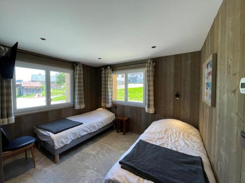 une chambre avec deux lits et deux fenêtres dans l'établissement Appartement rénové, 6 pers, 2 ch + coin montagne, centre Crest-Voland, parking, skiroom, WIFI - FR-1-733-16, à Crest-Voland